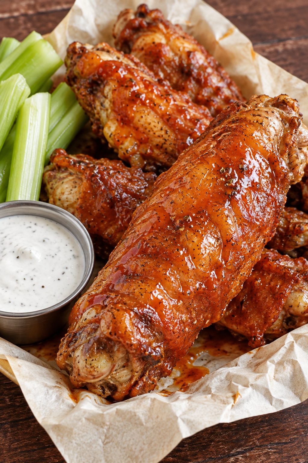Baked turkey wings on a table with sauce and celery