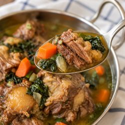 Beef oxtail soup in a dish with kale, and carrots