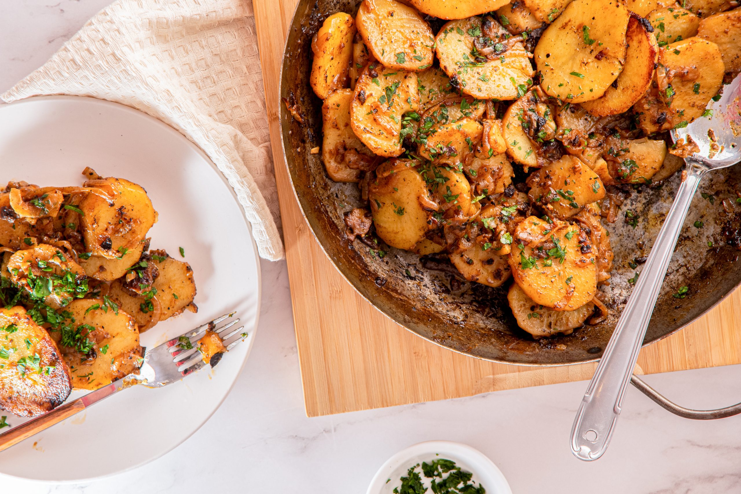 smothered potatoes on a plate and skillet
