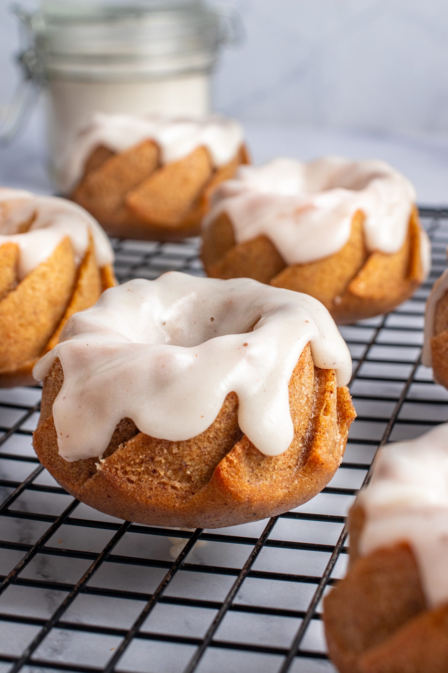 Glazed pumpkin bundt cakes on a cooling rack