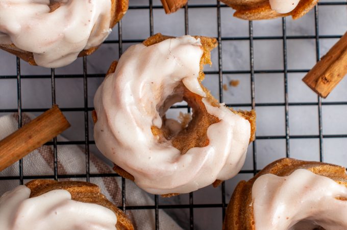 Top down view of mini pumpkin bund cakes on a cooling rack with a bite taken out of one