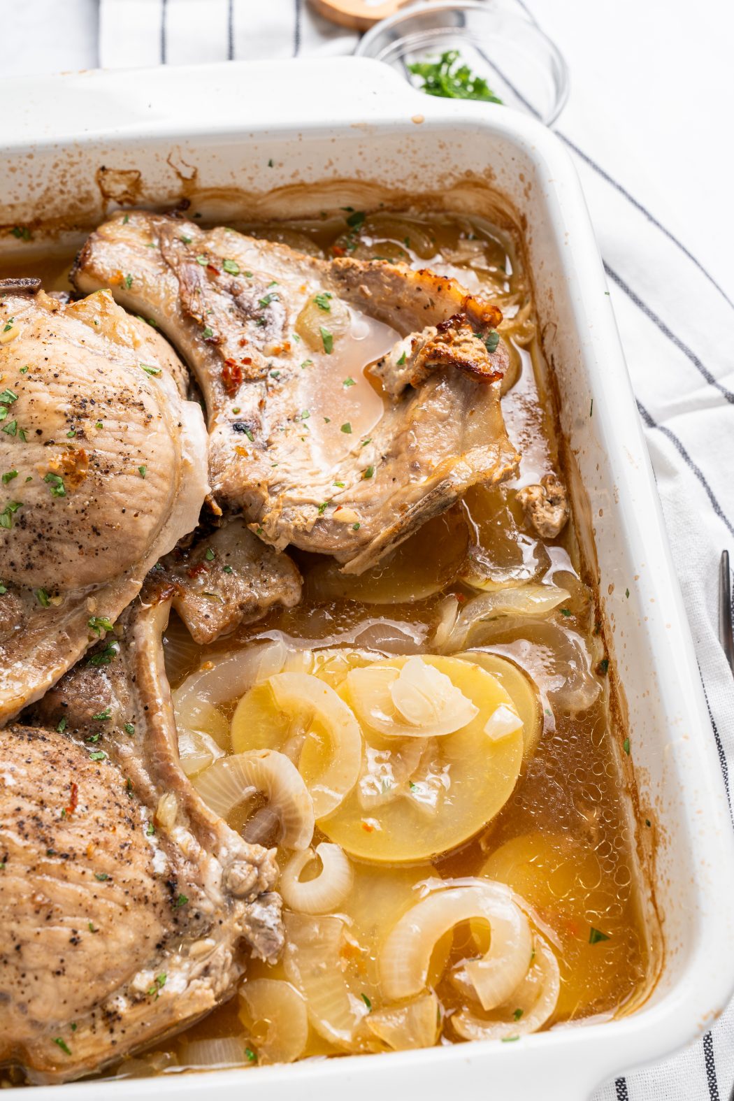 baked pork chops and potatoes in a baking dish
