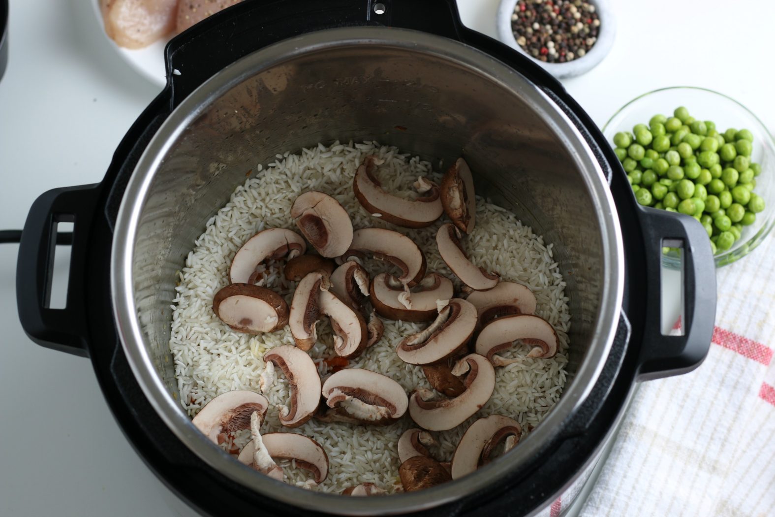 adding mushrooms and rice to Instant Pot chicken and rice recipe