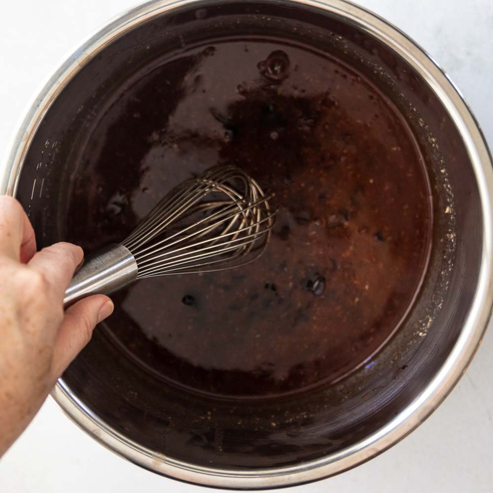 whisking grape jelly meatball ingredients together in an instant pot