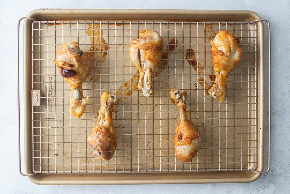 chicken legs on a wire wrack ready to go in the oven